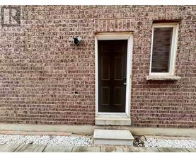 A brick wall with a door and a window.