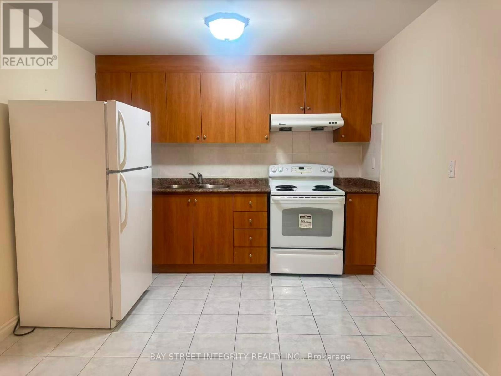 A kitchen with white appliances and wooden cabinets.