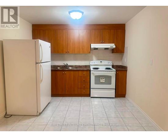 A kitchen with white appliances and wooden cabinets.