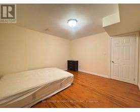 A bedroom with a bed, dresser, and a door.