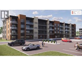 A rendering of a multi-story apartment complex with cars parked in the parking lot.