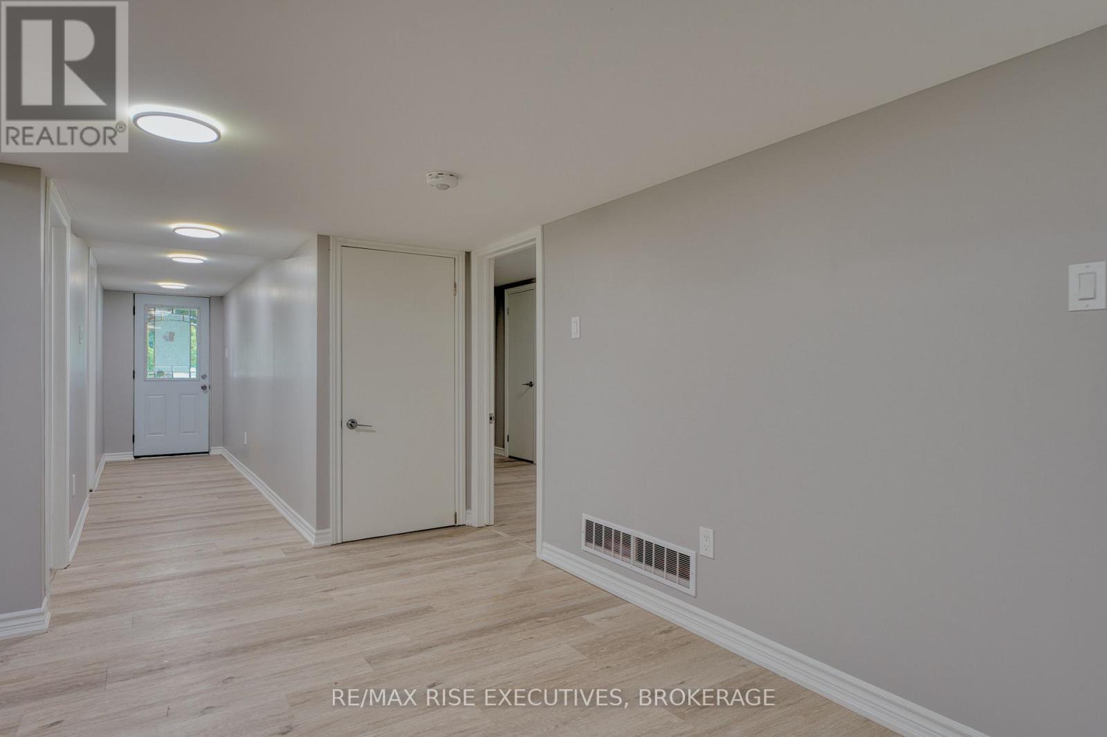A spacious room with a doorway leading to another room.