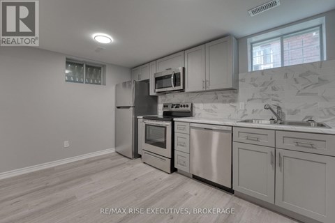A kitchen with a stove top oven, microwave, dishwasher, and sink.