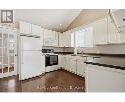 A kitchen with white cabinets and appliances is on the market with REVEL Realty Inc.