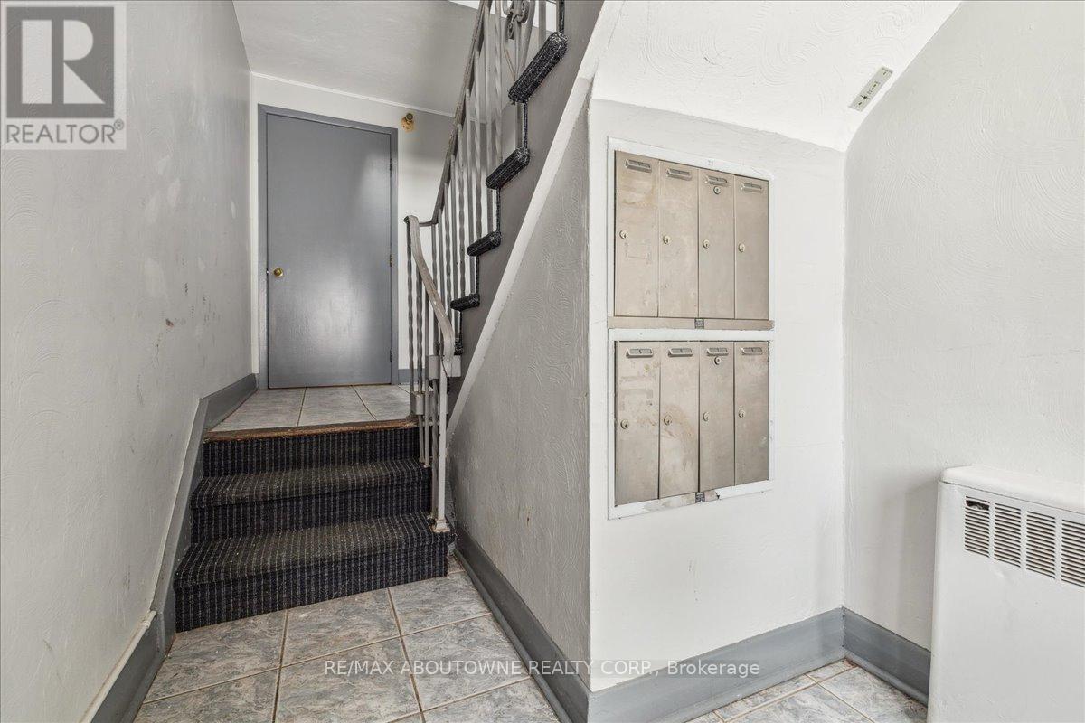 A hallway with a staircase and a wall with a panel of windows.