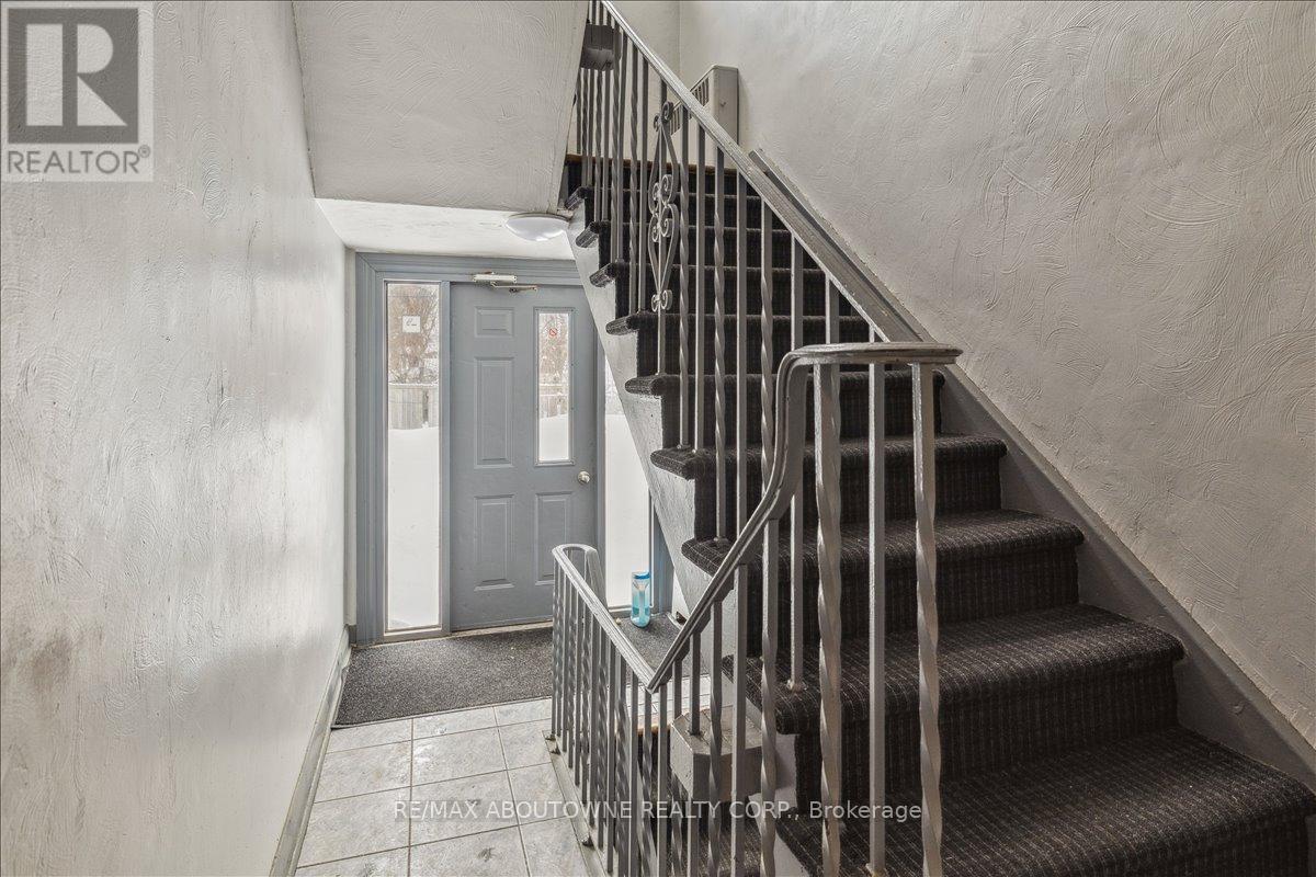 A staircase with a metal railing and a grey door at the end.