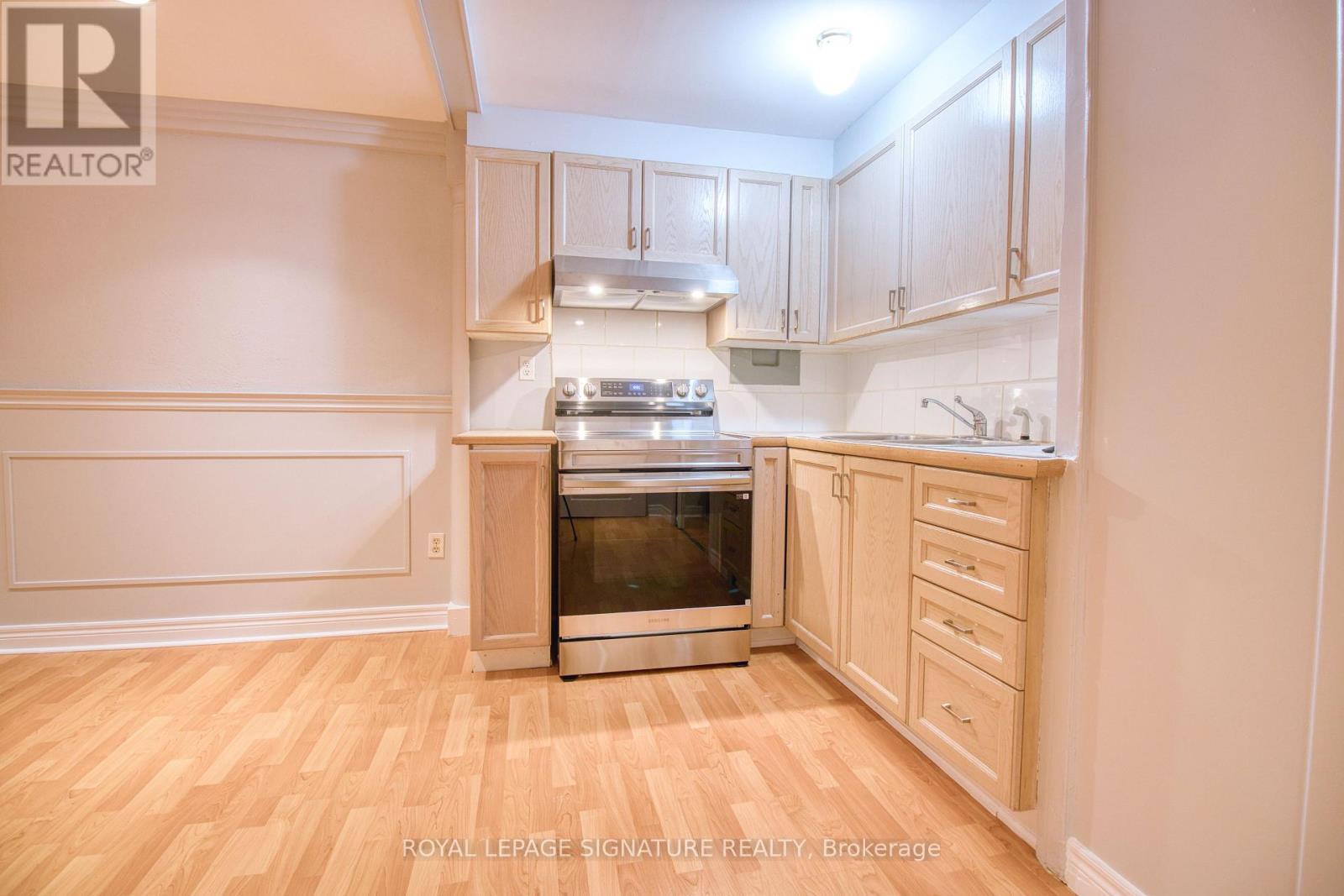 A kitchen with wooden floors and cabinets.