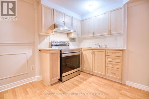 A kitchen with wooden cabinets and a stainless steel oven.