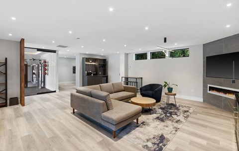 A modern living room with a grey sofa set and a black chair.