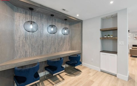 A modern kitchen with blue chairs and a wooden counter.
