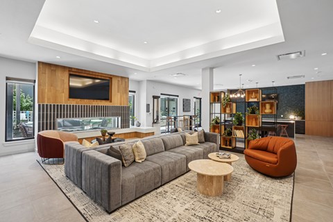 A modern living room with a grey sofa and a wooden coffee table.