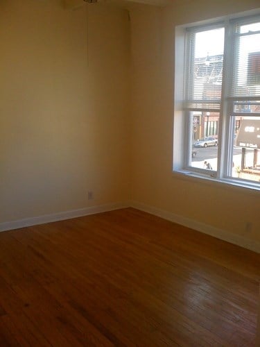 A room with a window and wooden floors.