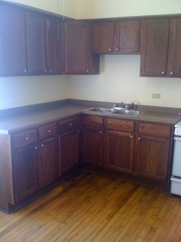 A kitchen with wooden cabinets and a white oven.