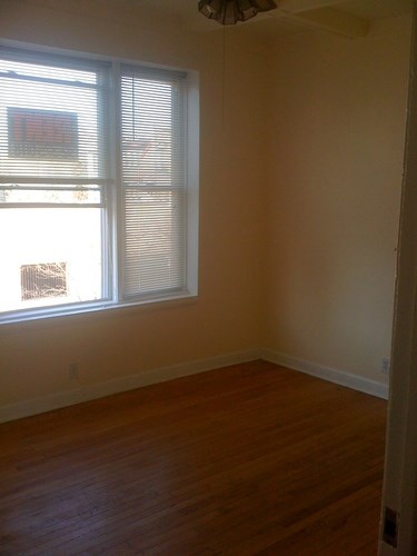 A room with a window and wooden floors.