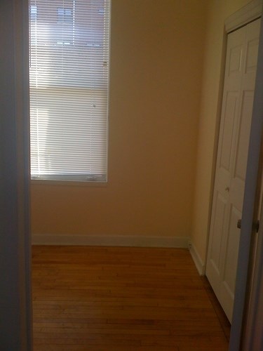 A room with a white door and a window with blinds.