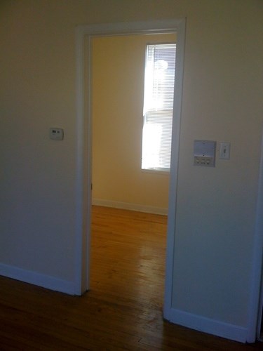 A white door is open to a room with a window.