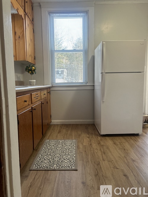 A kitchen with a white fridge and wooden cabinets.
