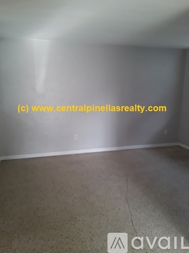 A room with a beige carpet and a white wall.