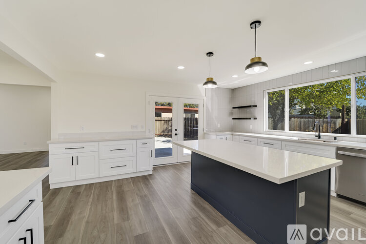 A modern kitchen with white cabinets and a large island.