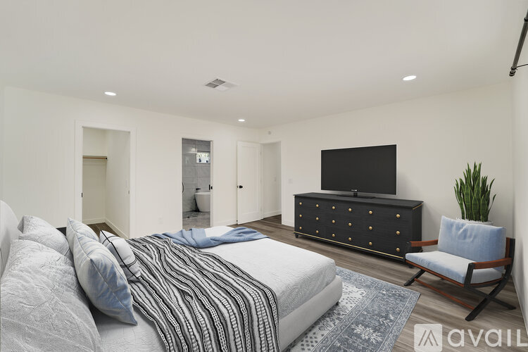 A bedroom with a bed, a dresser, and a chair.