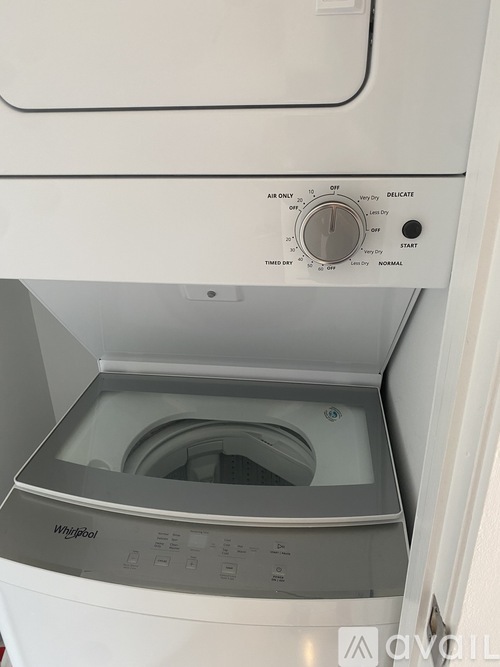 A white Whirlpool washing machine with the door open.