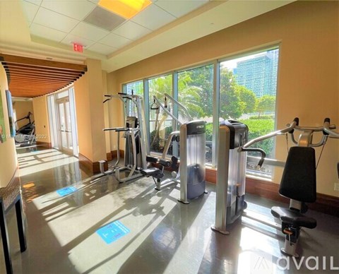 A gym with a variety of equipment including treadmills, weights, and exercise machines.