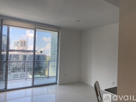 A room with a view of the city through large windows.