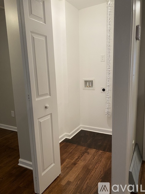 A white door is in a room with wood flooring.