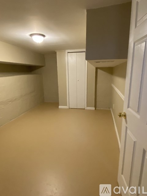 A hallway with a white door and a light on the ceiling.