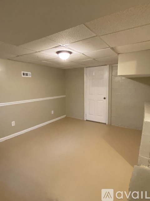 A room with a white door and a light on the ceiling.