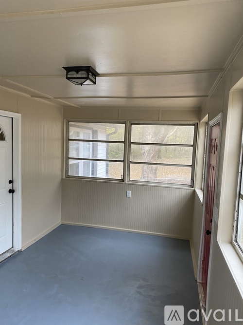A room with a door, a window, and a ceiling fan.