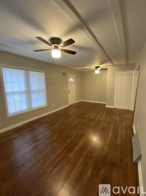 A room with wooden floors and a ceiling fan.