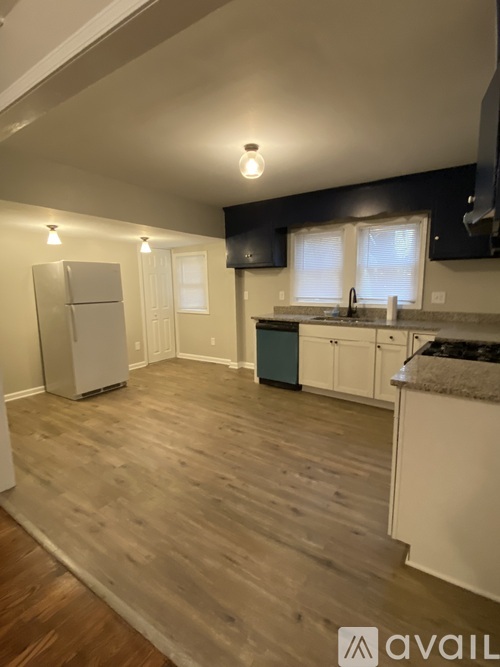 A kitchen with wooden floors and white appliances.