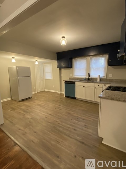 A kitchen with wooden floors and white appliances.