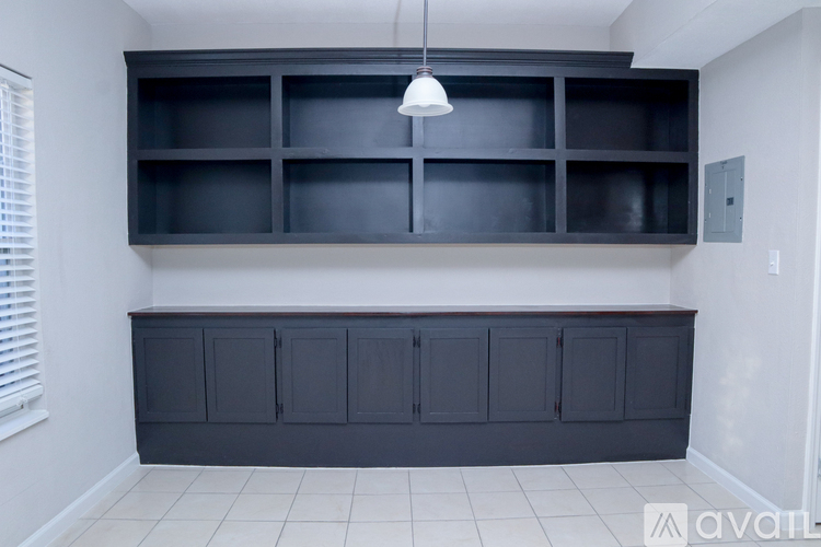 A room with a black shelf and a white cabinet.