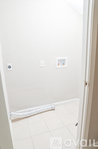 A white bathroom with a toilet paper holder and a towel rack.