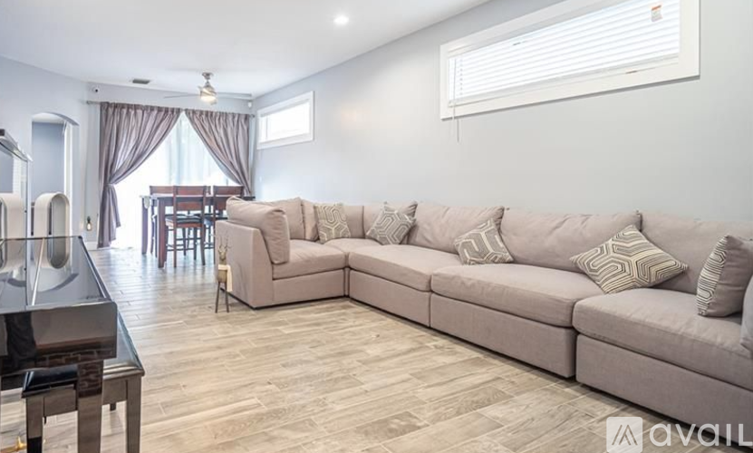 A living room with a large sectional sofa and a dining table.
