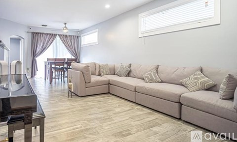 A living room with a large sectional sofa and a dining table.