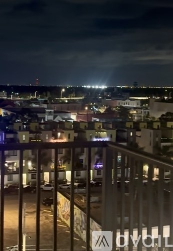 A cityscape at night with lights from buildings and street lamps.