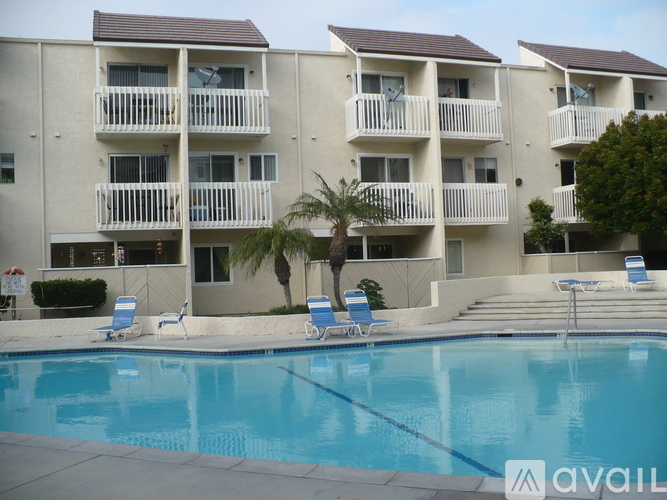 A large apartment complex with a pool in the foreground.