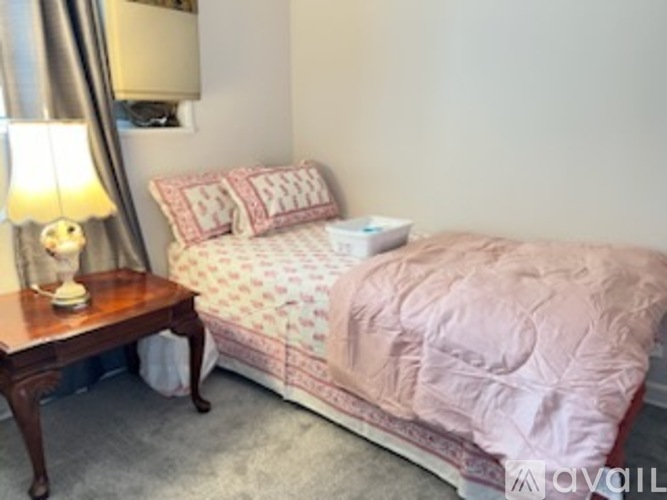 A bedroom with a bed, nightstand, and lamp.