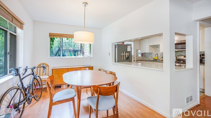 A dining room with a table and chairs and a bicycle.