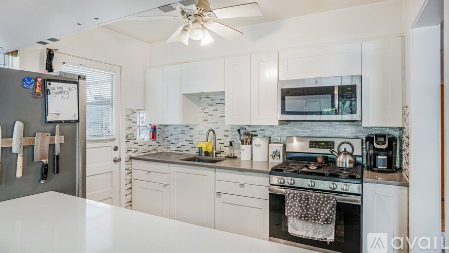 A kitchen with white cabinets and a black stove top oven.
