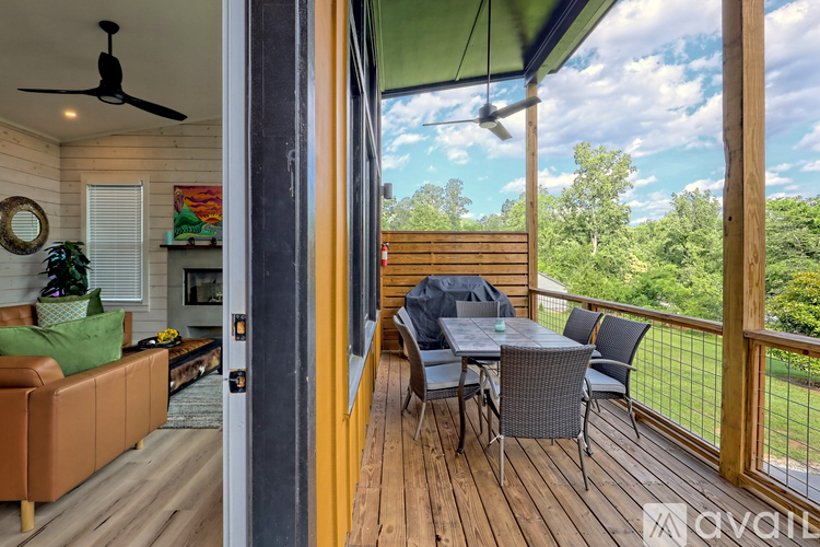 A balcony with a table and chairs overlooking a grassy area.