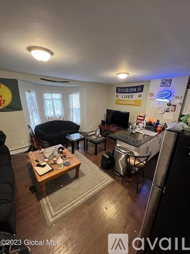 A living room with a couch, a coffee table, and a TV.