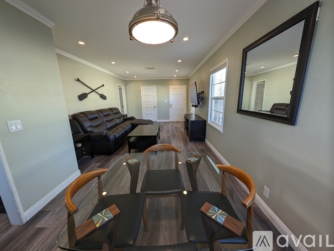 A modern living room with a black couch and a wooden coffee table.