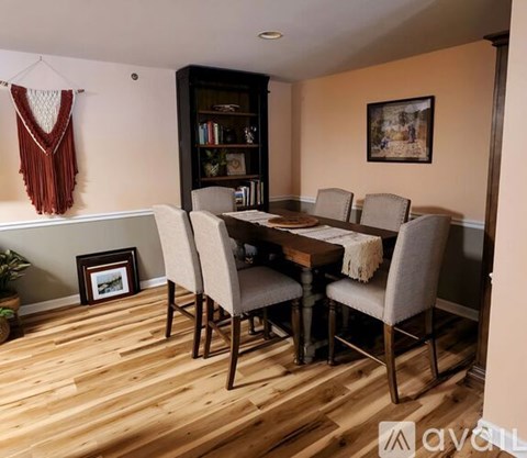 A dining room with a wooden table and chairs.