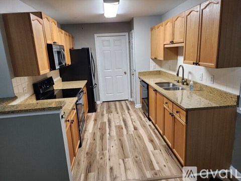 A kitchen with wooden floors and cabinets.