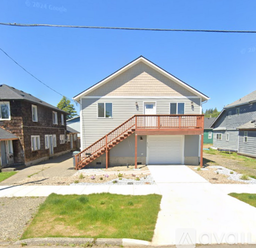 A house with a garage and a deck is surrounded by other houses.