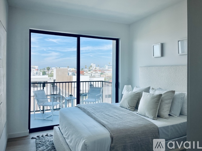 A bedroom with a large bed and a view of the city.